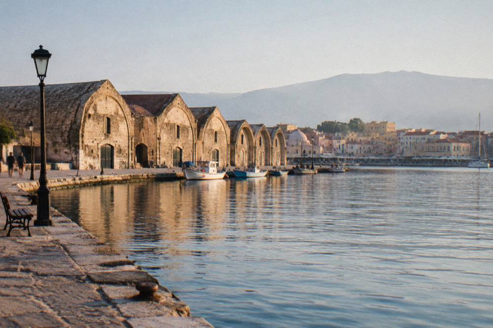 Rows of arched Venetian shipyard buildings, the Neoria, along the harbour edge in Chania