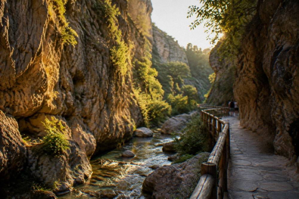 A narrow gorge with high rock walls and a footpath beside a stream
