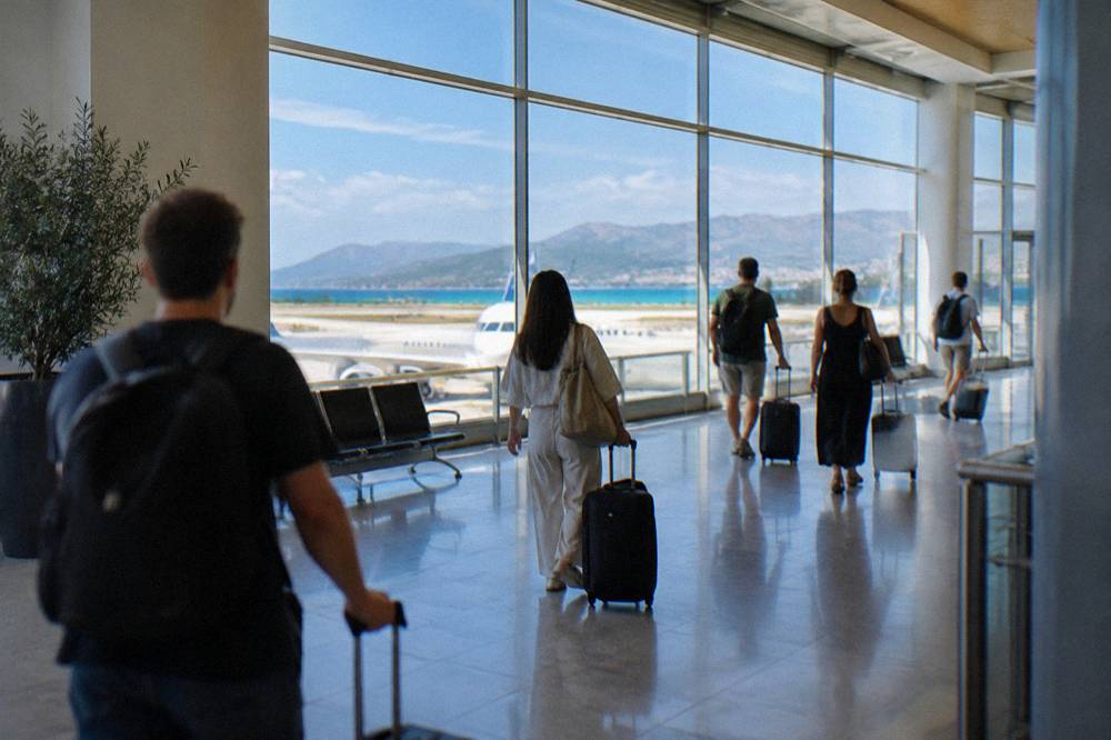 Travellers with suitcases walking through an airport arrivals hall