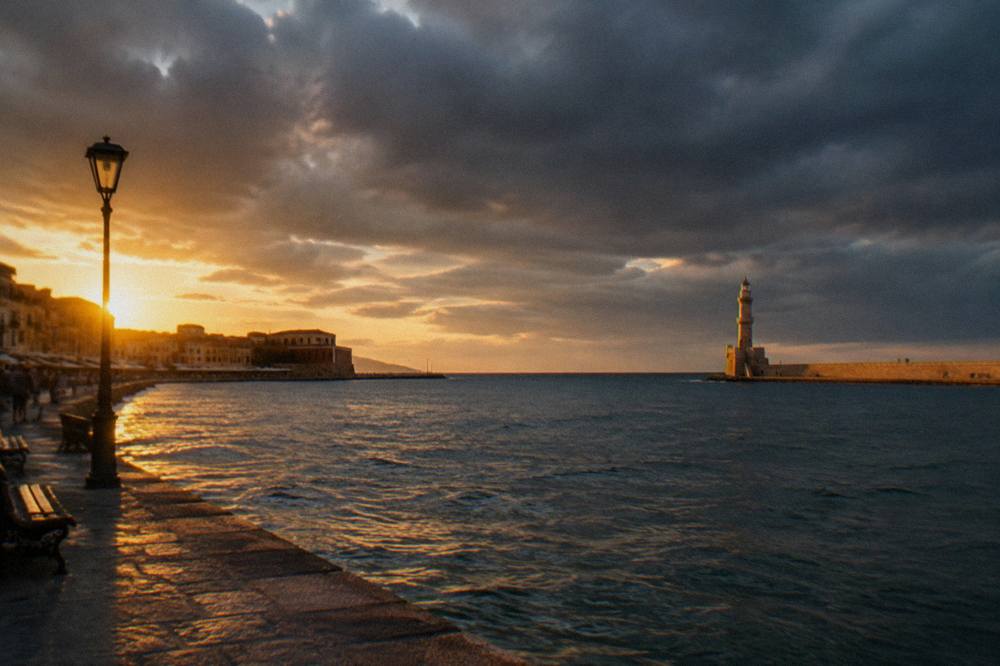 Dark clouds gathering over the Venetian Harbour of Chania with the lighthouse in the distance