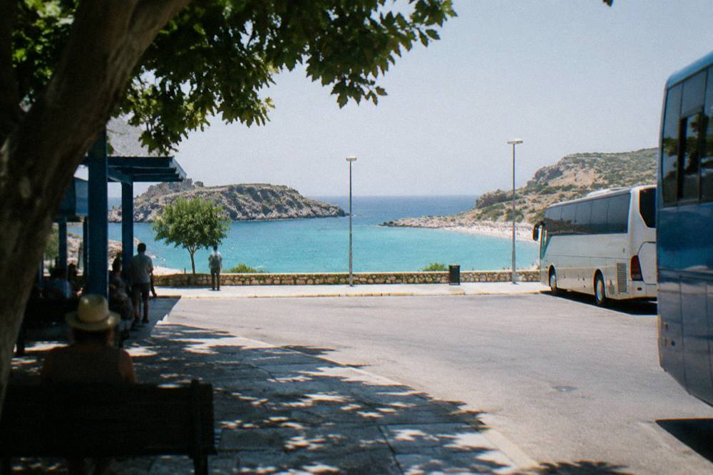A turquoise lagoon with a pale sandy beach enclosed by rocky headlands