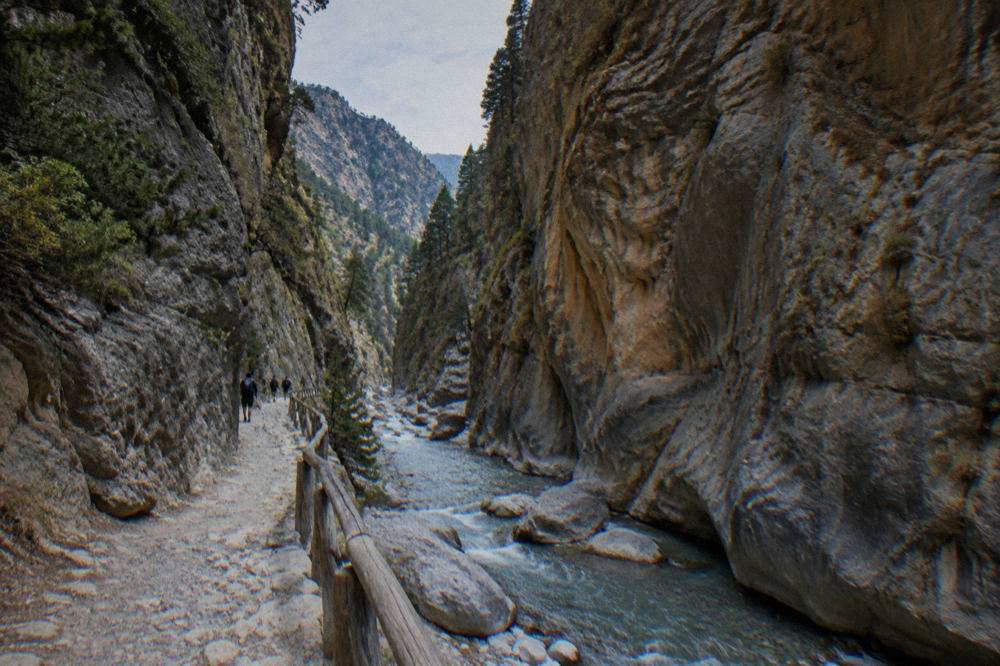A deep rocky gorge with a narrow stream running between high stone walls