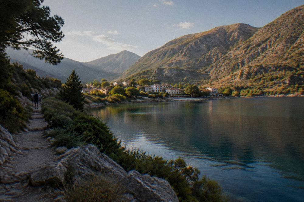 A calm lake ringed by hills with a small village on the shore
