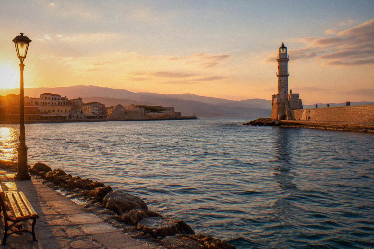 The Venetian Harbour of Chania with the lighthouse at the end of the breakwater in late afternoon light
