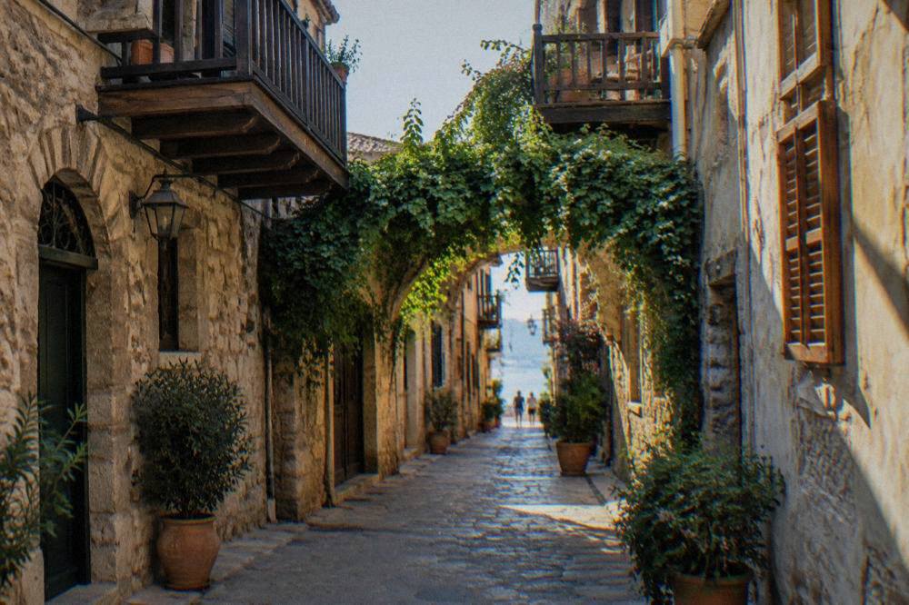 Narrow stone alley in Chania Old Town with wooden balconies and a vine-covered archway