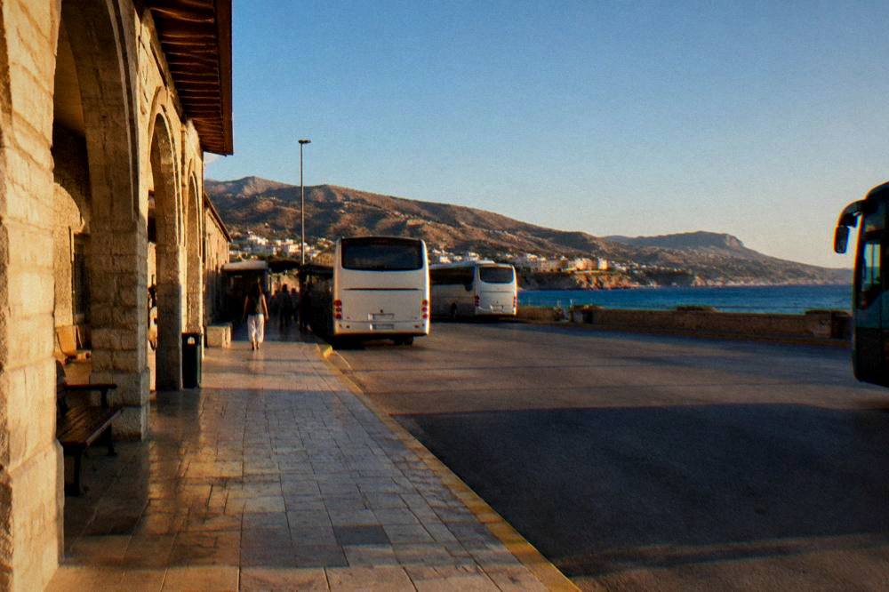 Coastal road in Crete under a clear blue sky with dry hillsides