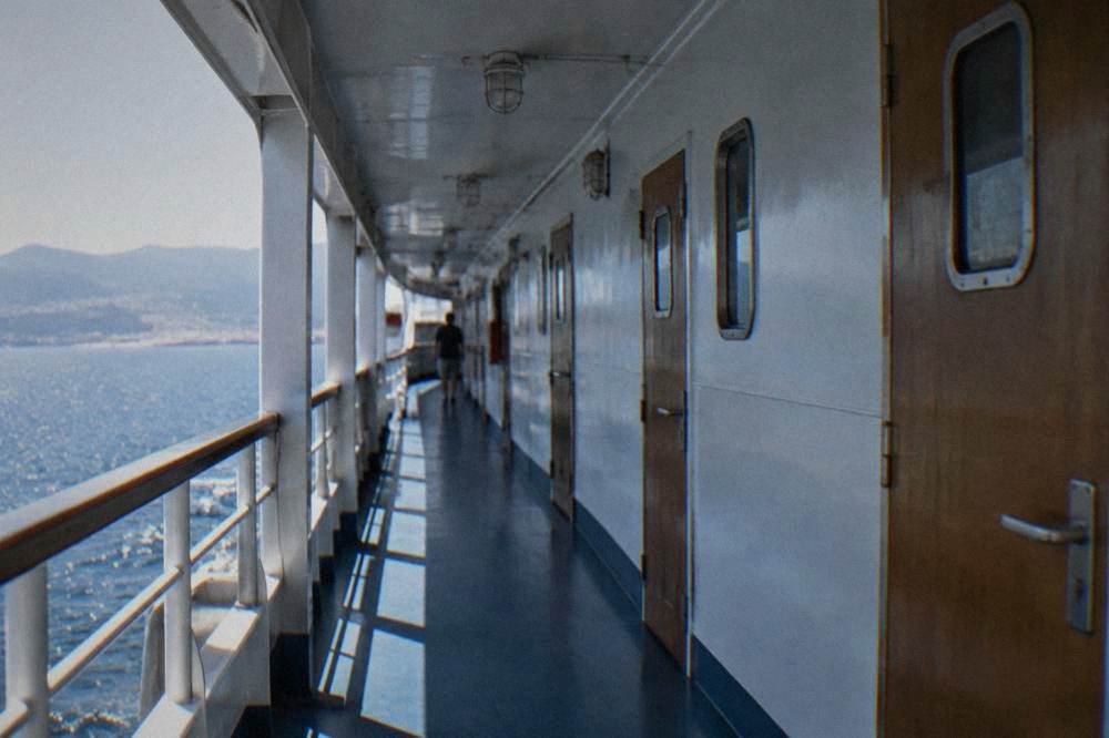 A ferry cabin corridor with numbered doors leading to private overnight cabins