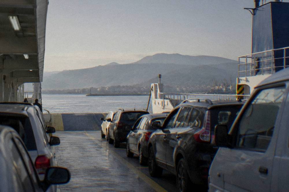 A car deck on a ferry with vehicles parked in rows ready to unload
