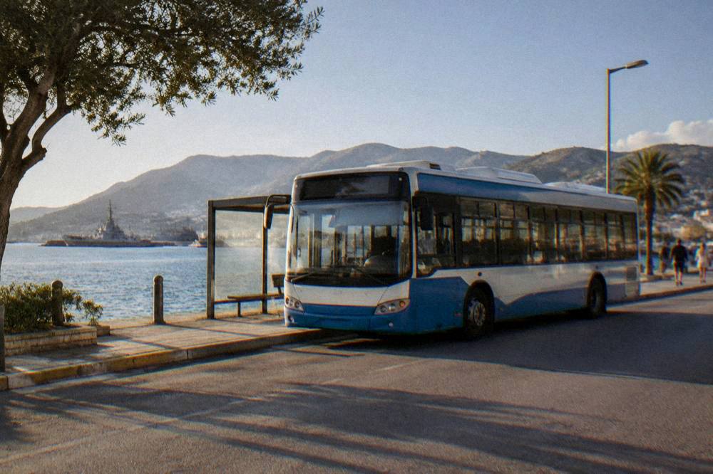 A public bus parked at a street-side station in a Greek town