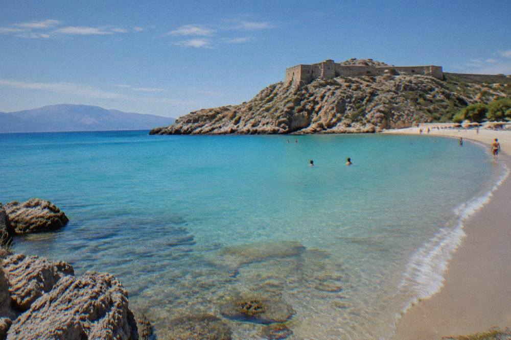 Turquoise shallows of a lagoon beach backed by a rocky headland on the west coast of Crete