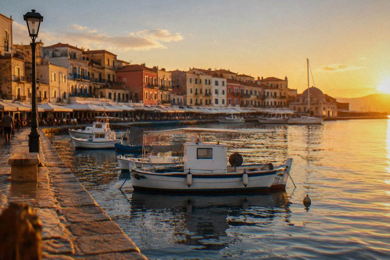 Harbour front buildings and boats along the water in Chania at golden hour