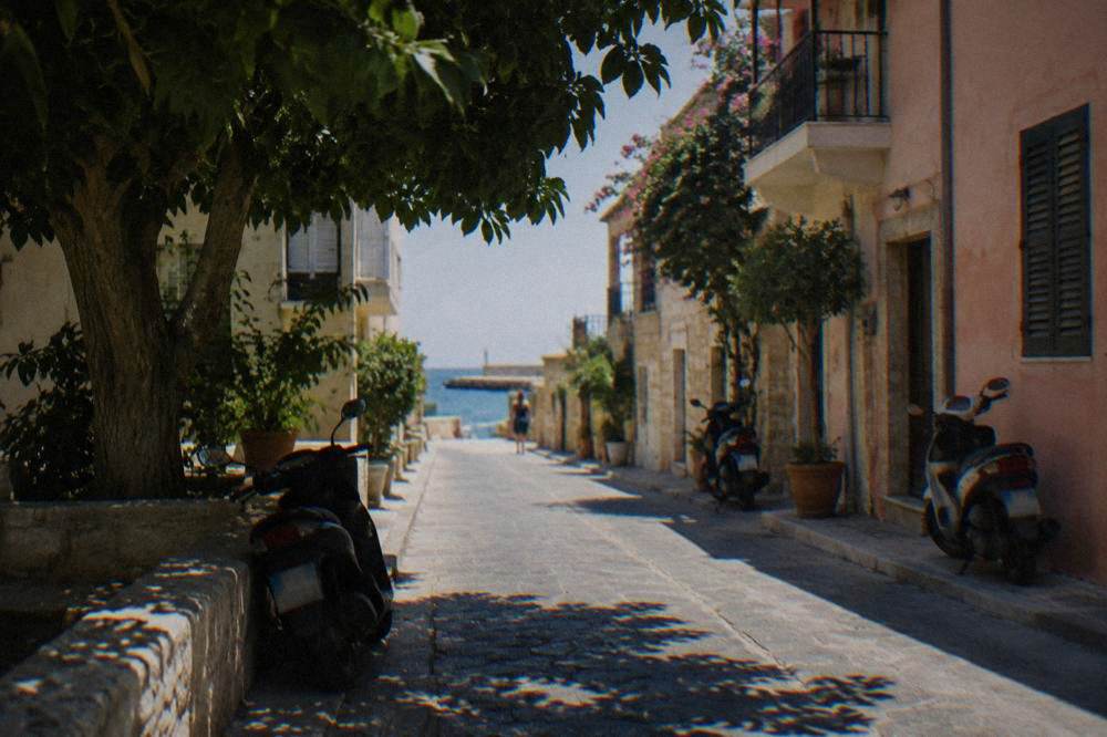 Quiet residential street with low buildings and parked scooters in a city quarter