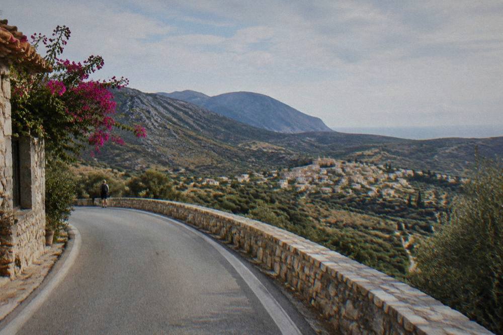 Winding mountain road above a valley with a village in the distance