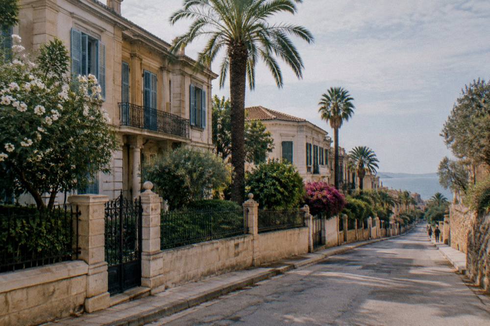 A quiet street of neoclassical mansions with shutters and palms in the Halepa quarter of Chania
