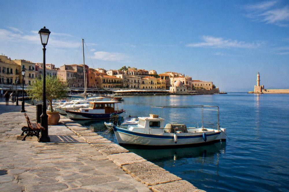 The stone quay promenade along the Chania harbour in early morning light