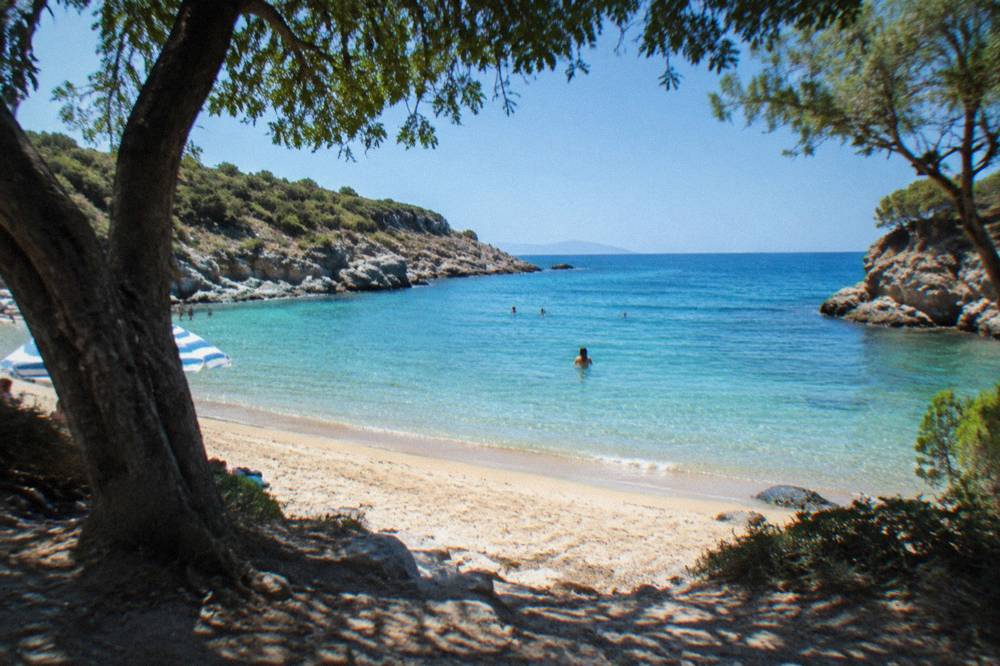 A sheltered sandy cove between rocky headlands with clear turquoise water near Chania