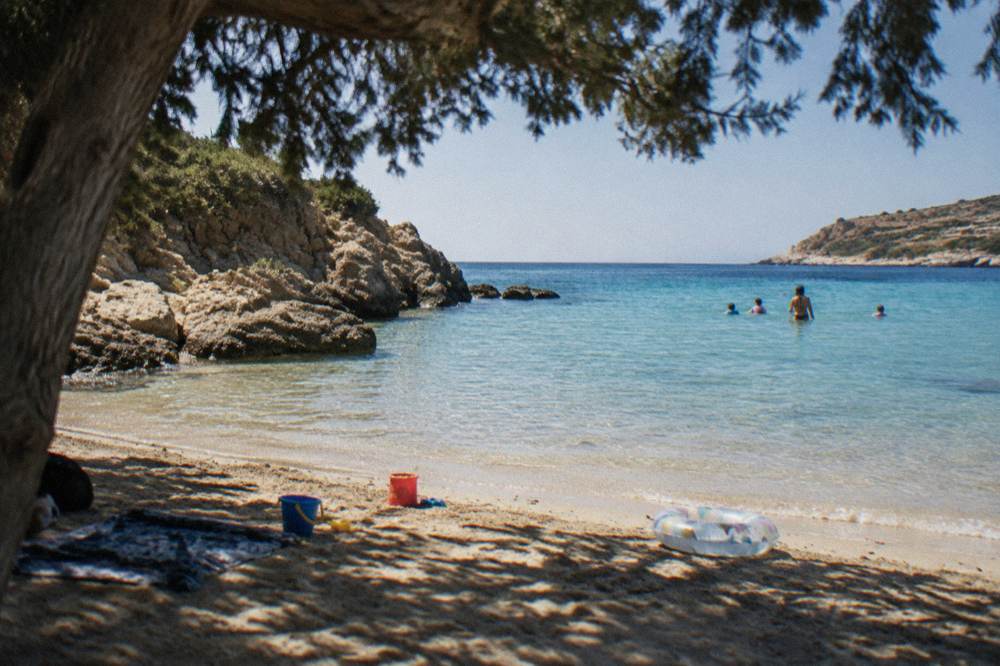 A shallow sandy cove with warm clear water and beach toys near Chania