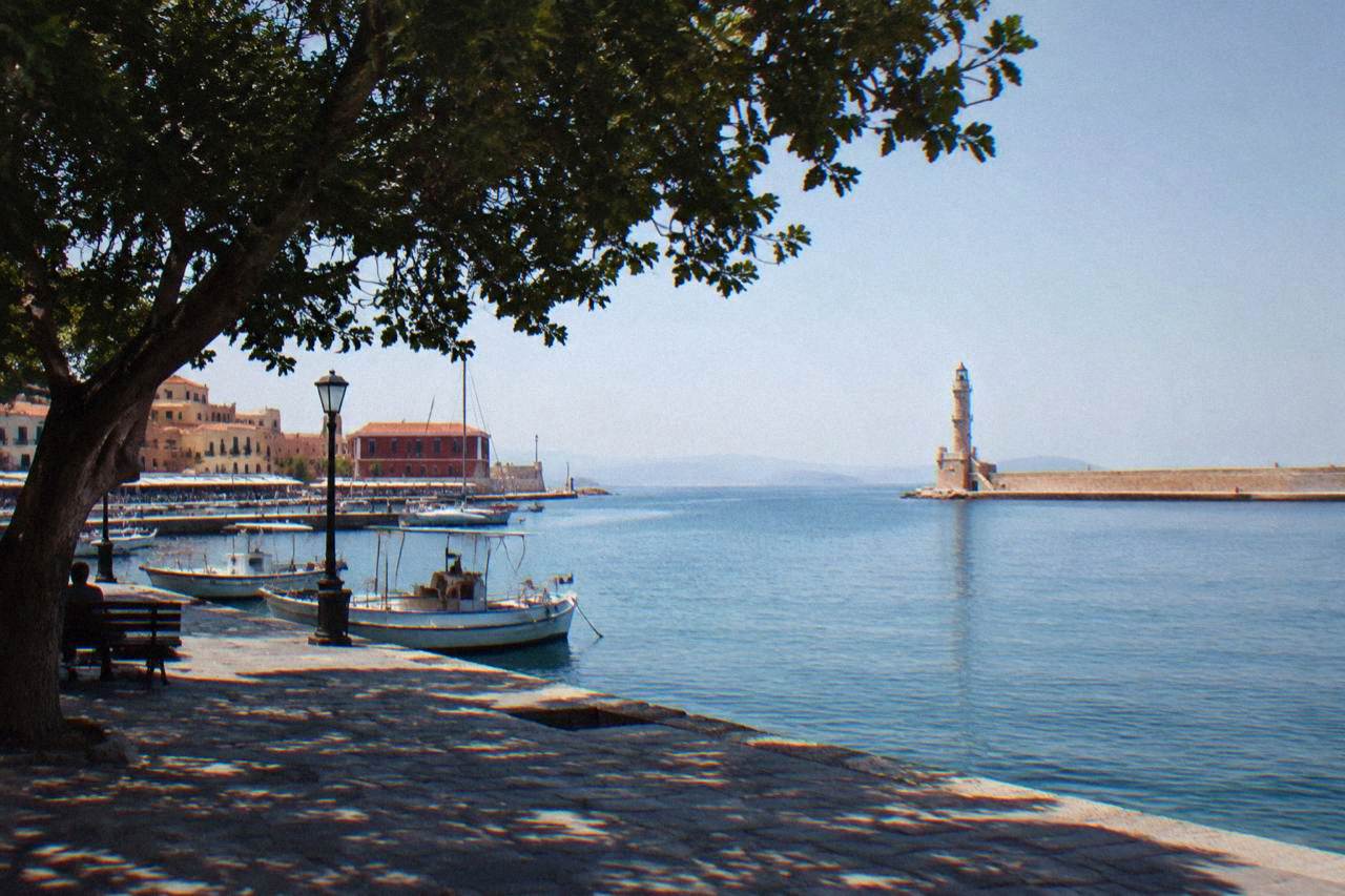 The Venetian Harbour of Chania with the lighthouse at the end of the mole and boats moored along the quay