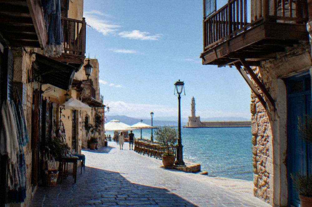 Narrow stone lanes of Chania Old Town with wooden balconies and shops in the shade