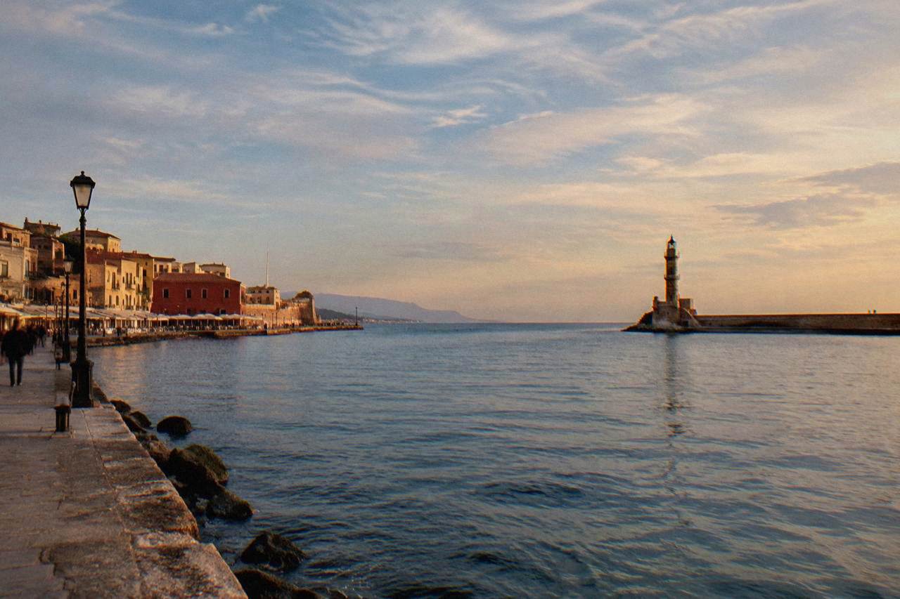 The Venetian Harbour of Chania with the lighthouse at the end of the breakwater in late afternoon light