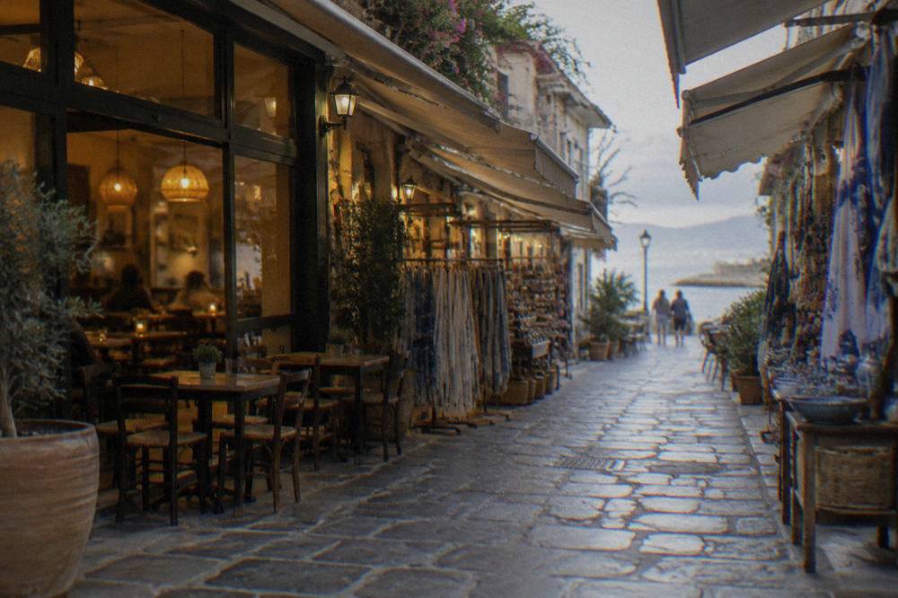 Covered shopping lane in Chania Old Town with awnings and a cafe lit from inside