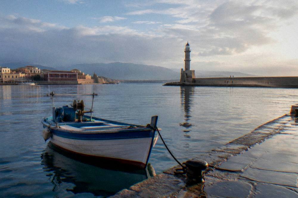 Small boat at a Chania harbour quay under a clearing sky after rain