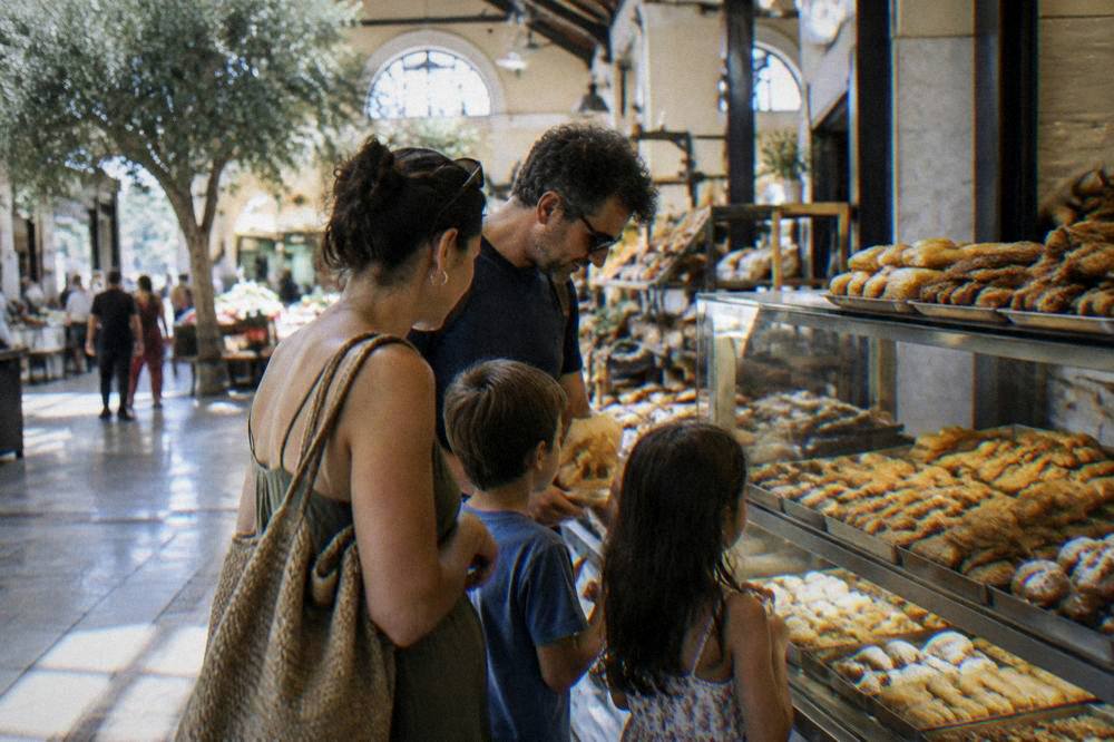 Family sharing pastries at a bakery counter inside the municipal market hall