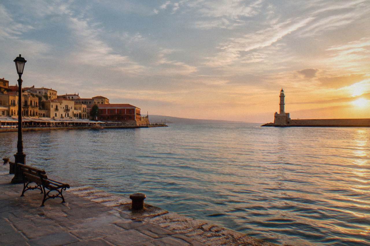 The Venetian Harbour of Chania at golden hour with the lighthouse at the end of the breakwater