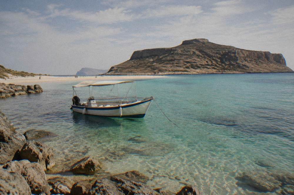 A boat moored in the turquoise shallows of Balos lagoon in Crete