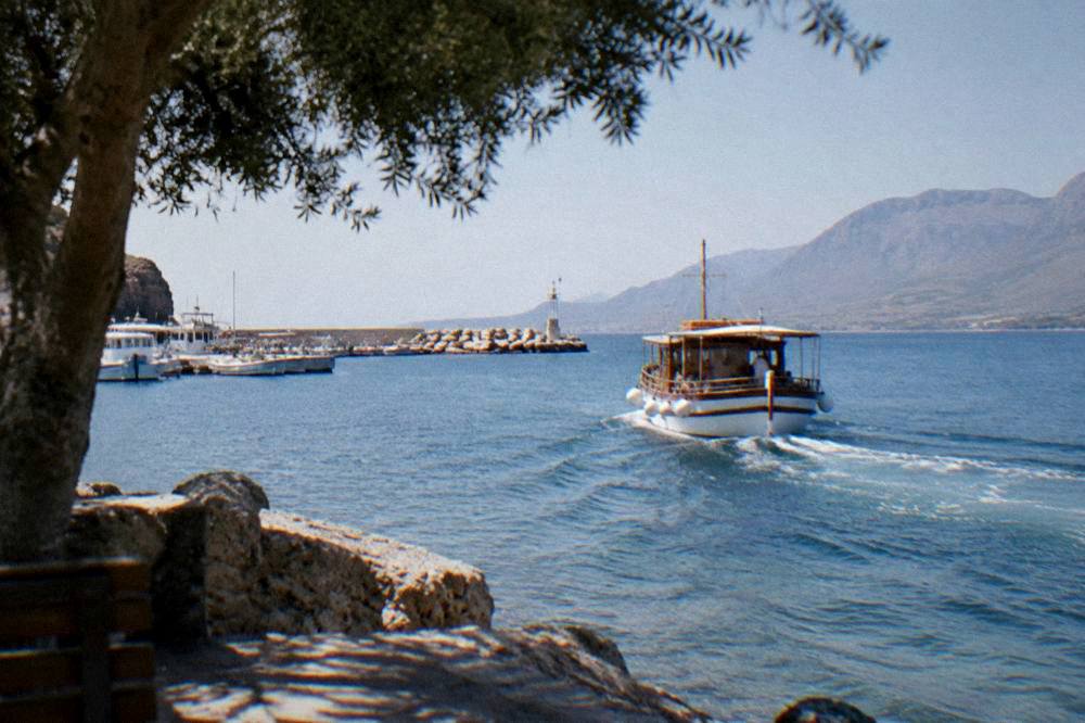A wooden day boat leaving the small port of Kissamos in morning light